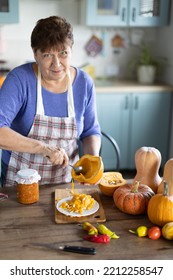 Elderly Woman Cooking Pumpkin In The Kitchen