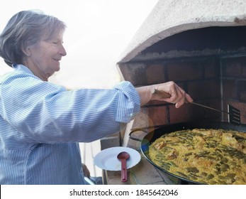 
Elderly Woman Cooking A Valencian Paella