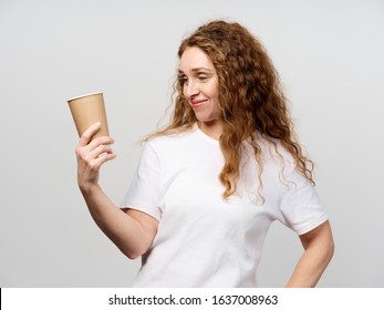 Elderly woman with curly hair hold a cup of coffee in hand