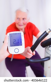 Elderly Woman Doing Sport Effort On A Spinning Bike Having Hear Hart Rate And Blood Pressure Monitored.