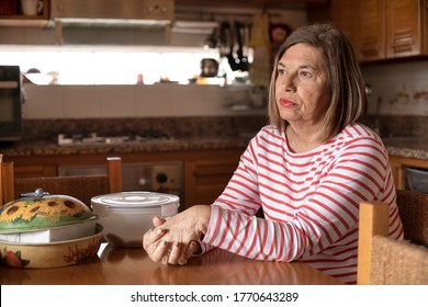 Elderly Woman Dressed Casual And Sitting With Serious Expression On The Sofa Of Her Home