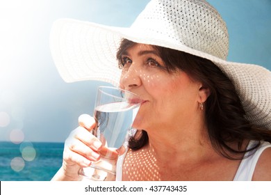 Elderly woman driking water by the sea - Powered by Shutterstock