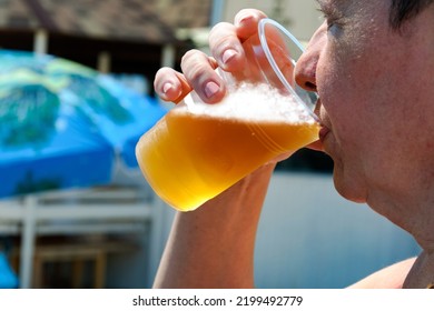 Elderly Woman Drinking Beer On The Beach. Sunny Day, Summer.