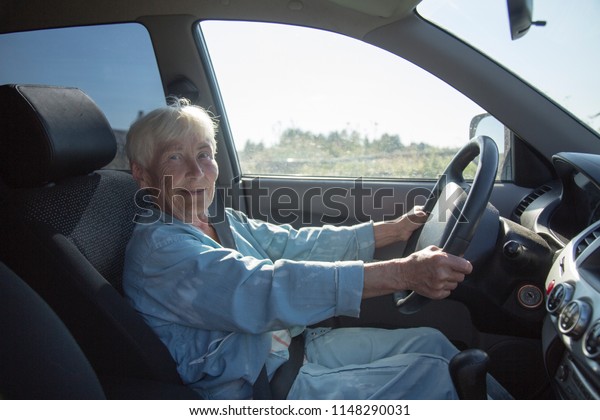 an elderly woman\
driving