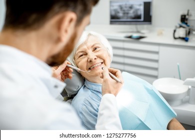 Elderly woman during the medical examination with male dentist in the dental office
