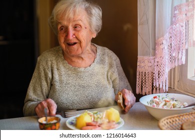 Elderly Woman Eat Sitting At Dinner Table At Home.