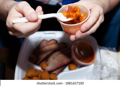 Elderly Woman Eating Baked Beans From A Brisket Takeout Meal