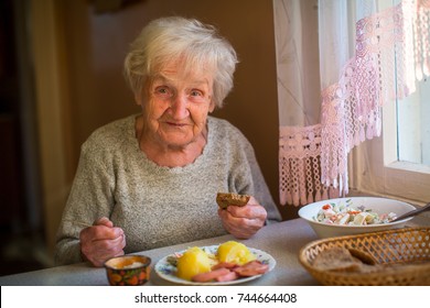 An Elderly Woman Eats At Home.