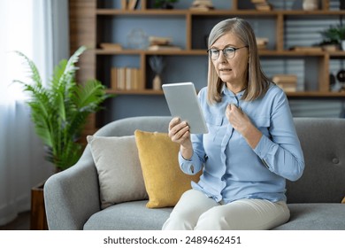 An elderly woman engages in virtual consultation with psychologist, displaying frustration and concern while sitting on sofa at home. Concept includes mental health, online therapy - Powered by Shutterstock