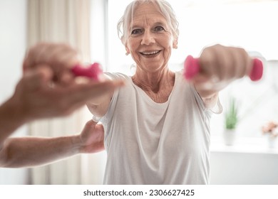  A elderly woman engaging in rehabilitative exercises under the guidance and support of physiotherapist - Powered by Shutterstock