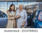 Elderly woman enjoying a day out with her daughter, smiling together beside a parked car. Captures a moment of family joy and togetherness.