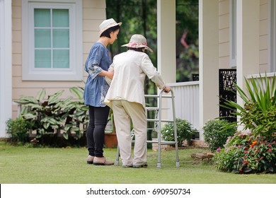 Elderly Woman Exercise Walking In Backyard With Daughter