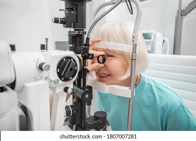 Elderly woman eyesight test with binocular slit-lamp. Checking retina of a female eye close-up. Ophthalmology Clinic - Powered by Shutterstock