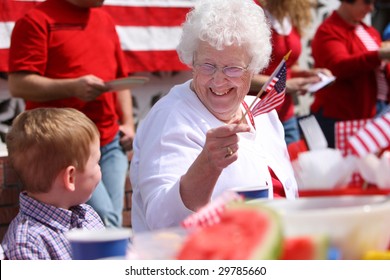 Elderly woman at family barbeque waving American flag