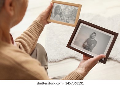 Elderly Woman With Framed Photos At Home