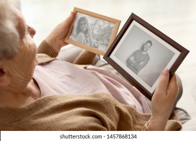 Elderly Woman With Framed Photos At Home