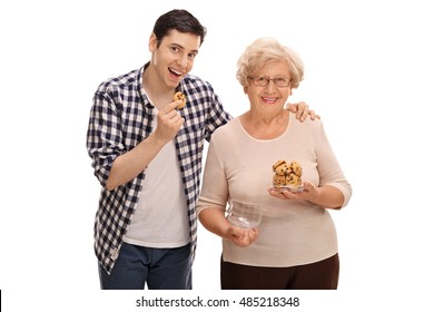 Ältere Frau, die einem jungen Mann Kekse gibt einzeln auf weißem Hintergrun...