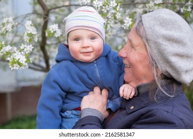 Elderly Woman Grandmother Holding A 9 Month Baby In Her Arms