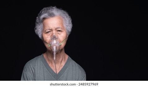 Elderly woman with gray hair wearing an oxygen mask against a dark background represents health care and respiratory assistance. Perfect for themes of aging and medical support. - Powered by Shutterstock