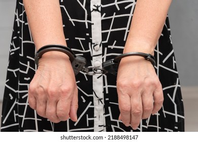 An Elderly Woman In Handcuffs On A Blurry Background In An Apartment. An Elderly Criminal, Criminal Liability Of Pensioners, Domestic Violence Against Women.