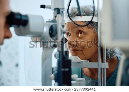Elderly woman having her eyesight checked at ophthalmology clinic.