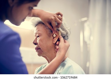 An elderly woman with hearing aid - Shutterstock ID 1062719684