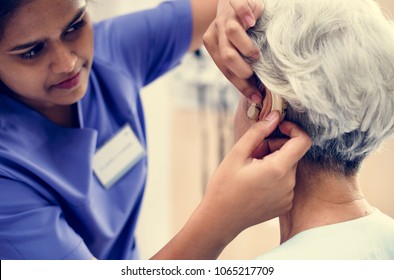 An elderly woman with hearing aid