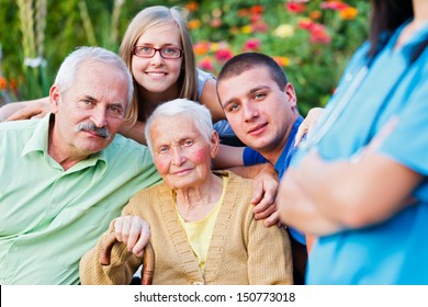 Elderly Woman With Her Family Supervised By A Doctor.