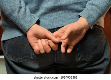 Elderly Woman Is Holding Her Hands Behind Her Back.
Closeup Of A Hand Gripping The Other Two Fingers.
Thoughtful Gestures.