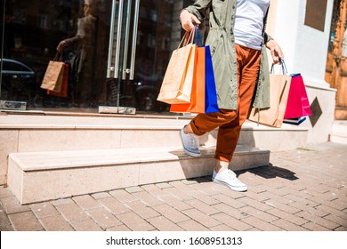 Elderly Woman Holding Shopping Bags And Leaving The Store Stock Photo