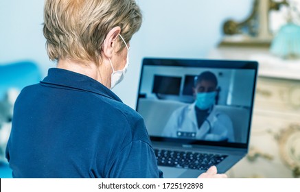 Elderly Woman At Home With Coronavirus Wearing Mask Visited By Doctor In A Videocall. Tele Medicine Concept.