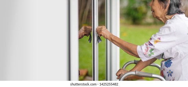 Elderly Woman With Key Opening Front Door.