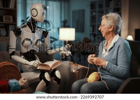 Elderly woman knitting on a sofa with her companion android reading a book in the living room. Concept of elderly care and future.