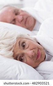 Elderly Woman Lying In Bed With Husband Can't Sleep