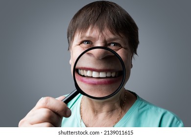 Elderly Woman With A Magnifying Glass In Her Hands.