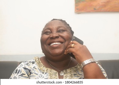 an elderly woman making a call and laughing