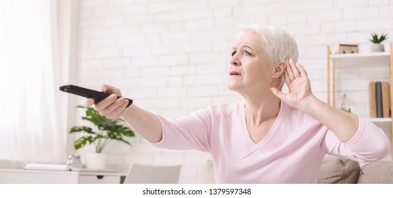 Elderly Woman Making Hearing Sign, Rising Tv Set Volume With Remote Control, Panorama