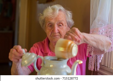 Elderly Woman Making Tea In The Kettle.