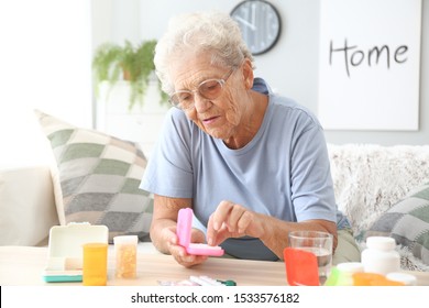 Elderly woman with medicines at home - Powered by Shutterstock