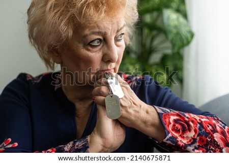 elderly woman with a military dog tag