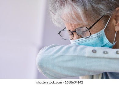 Elderly Woman With Mouthguard When Coughing In The Crook Of The Arm As A Prevention Against The Spread Of Coronavirus