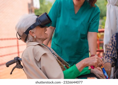 An elderly woman with the nurse looking through virtual reality glasses in the garden of a nursing home, vr glasses with an open mouth - Powered by Shutterstock