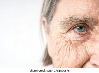 Elderly woman old eye and wrinkled face. Fragment of the portrait. Copy space.