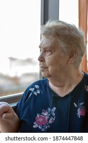 Elderly Woman On The Balcony By The Window.