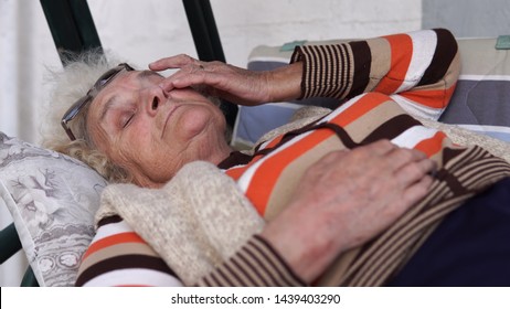 Elderly Woman On Porch Swing Bed Lying And Looking Sad At Distance