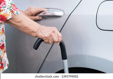 Elderly Woman Open Car Door And Holding Walking Stick