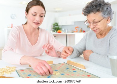 Elderly Woman Playing A Board Game