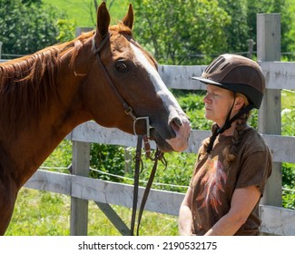 An Elderly Woman Playing With Her Horse