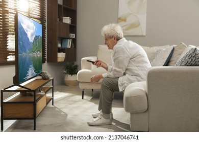 Elderly Woman With Poor Posture Watching TV In Living Room