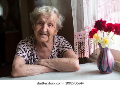 Elderly Woman Portrait Near Window In The House.